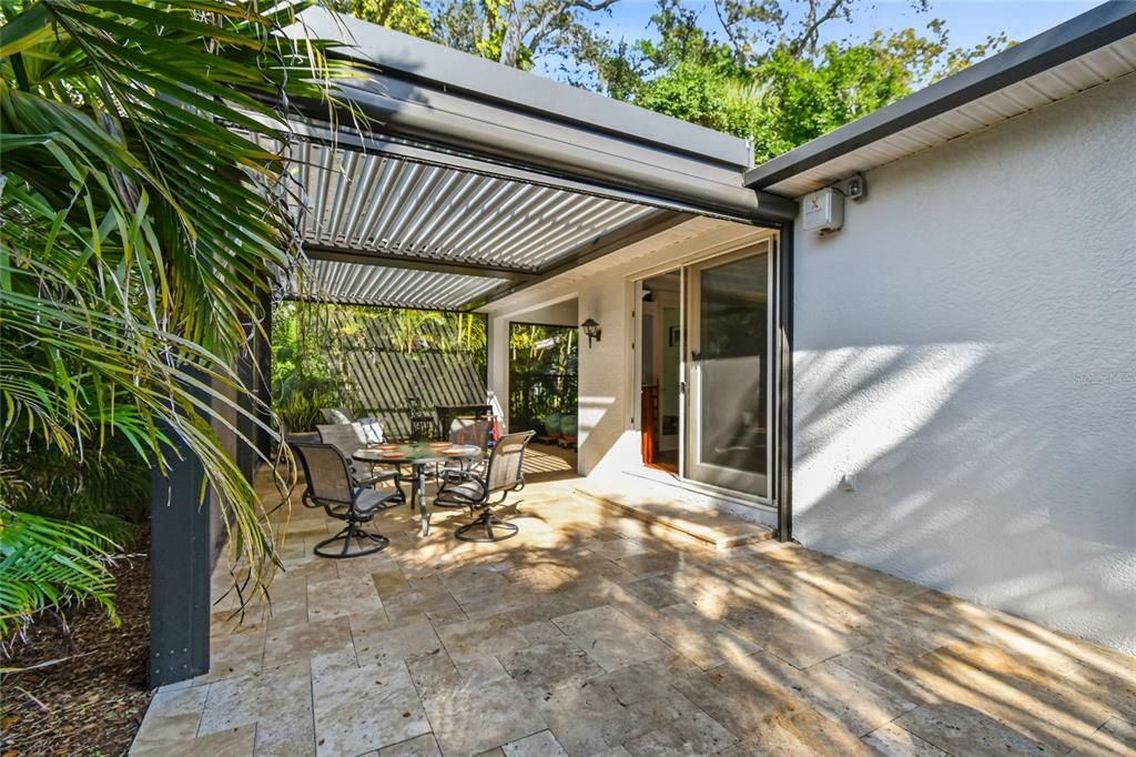 Travertine tile patio extends outside the screened in area