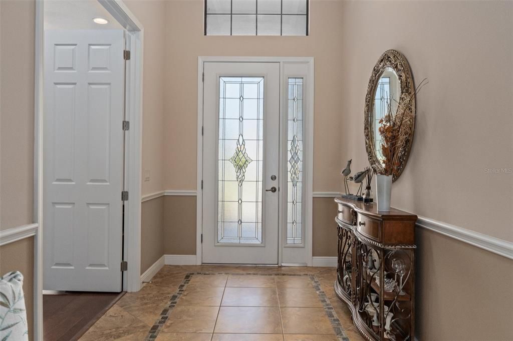 The spacious entry is bathed in natural light through the leaded glass front door. The doorway to the left features 2 solid French doors and leads into the flex room, currently used as a den, but could easily become a 3rd bedroom.