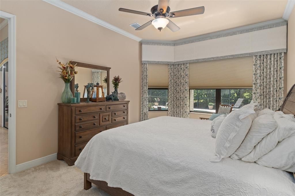 The Primary Bedroom's decor is finished with Crown Molding, pleated shades that can be opened at the top and bottom.