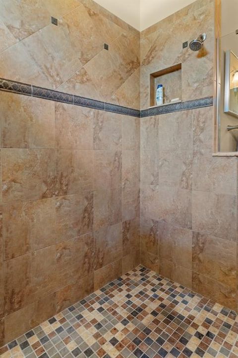 The generous shower features accent Lostillo Tiles and a handy shampoo niche.