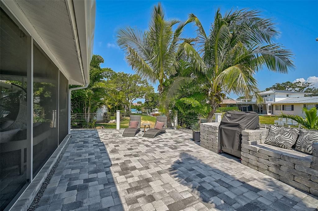 Upper Level Water Front Paver Terrace w Stone Table, Seating, and Grill