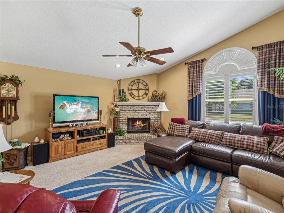 Large Family Room w/fireplace, large window and plantation shutters