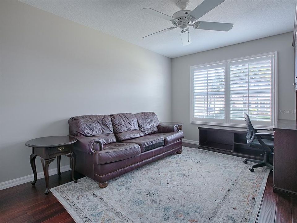 GUEST ROOM/OFFICE/DEN (THIS ROOM DOES HAVE A CLOSET) OFF THE DINING ROOM.  LOVELY HARDWOOD FLOORING IN THIS ROOM WITH PLANTATION SHUTTERS AND CEILING FAN.