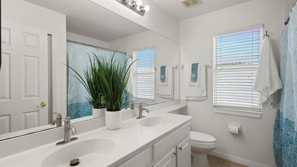 Upstairs Bathroom with dual sink and shower and bathtub combo