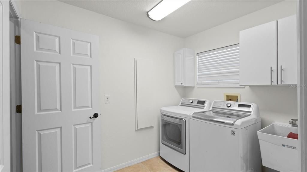 Laundry room with storage closet under stairs