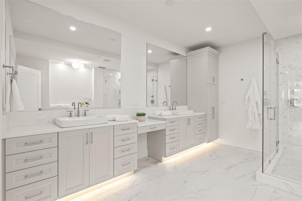 Double sink vanity in the primary bathroom and a floor-to-ceiling linen closet