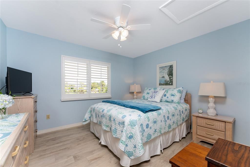 Spacious guest bedroom features laminate flooring and Plantation shutters.