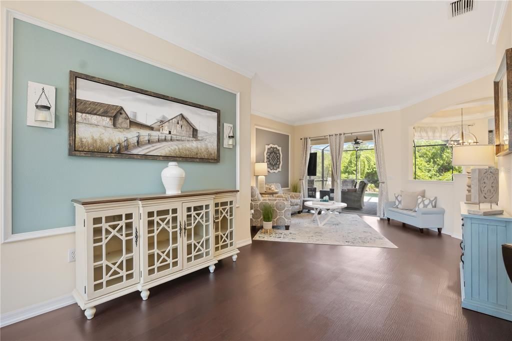 Welcoming large open foyer with designer wall decor seamlessly flows into living room, Florida room is spacious with a luxury, casual feel, ceramic tile flooring.