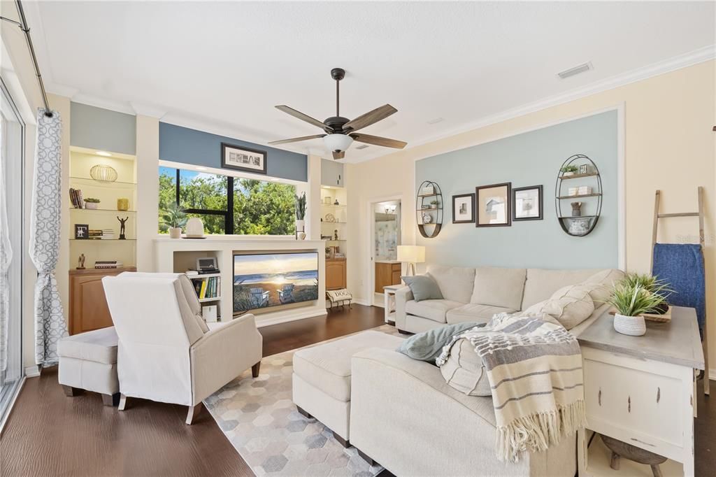 High ceilings with crown molding and decorative design creating a welcoming space in family room, access to the fourth bathroom.