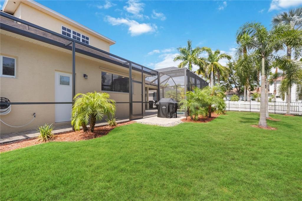 Lush tropical landscaping surrounds the spacious backyard.