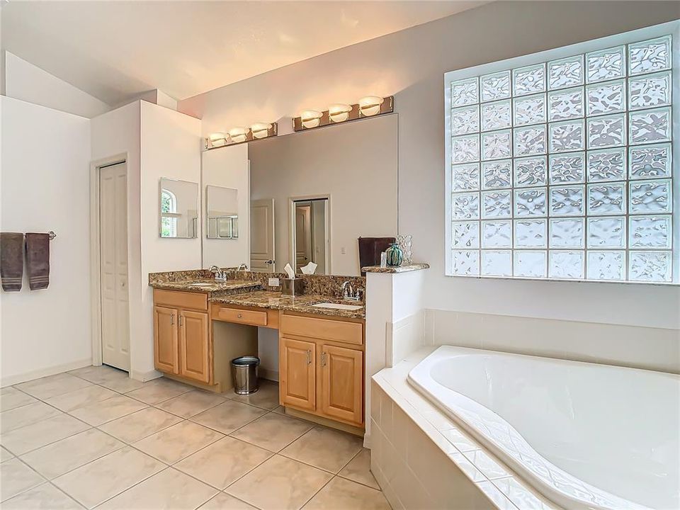 Spacious primary bathroom with high ceilings and plenty of natural light.