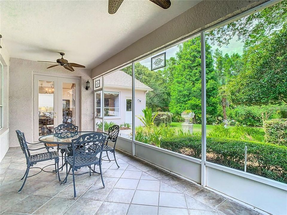 Covered and screened porch overlooks your beautifully manicured lawn and garden.