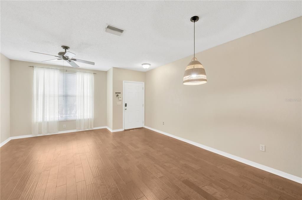 The living/dining room is 20 x 11’ with high ceilings, neutral wall color and plenty of natural light and room for furniture.