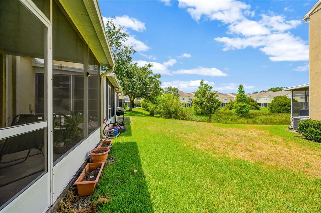 View of the green space in between townhouse units and the retention pond beyond.