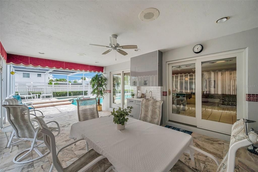 Another view of the protected patio area with double pane sliding doors for access to the house.  Note the built in speaker above next to the ceiling fan.