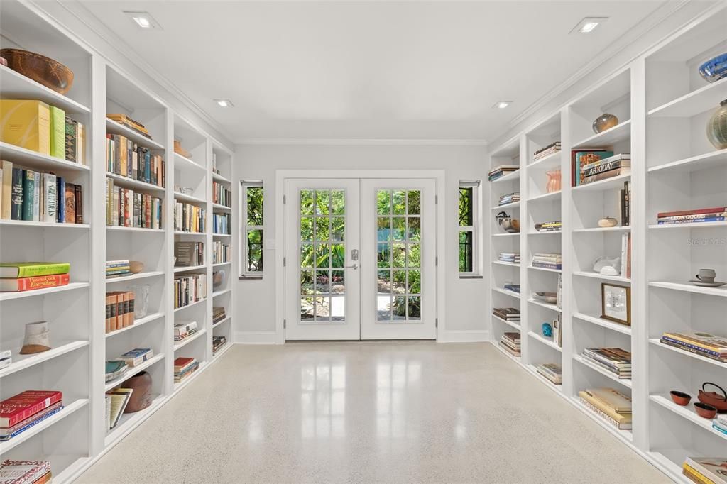 A fabulous built-in bookcase library offers a stunning entrance after gorgeous French doors.