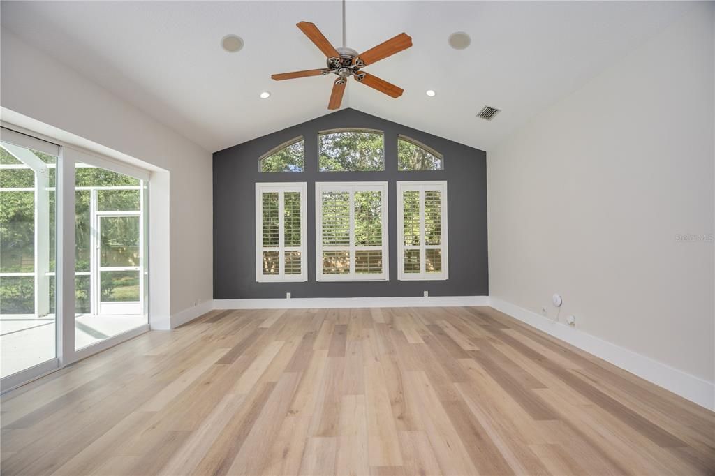 Oversized bonus room with high vaulted ceilings, custom baseboards and floor to ceiling windows.