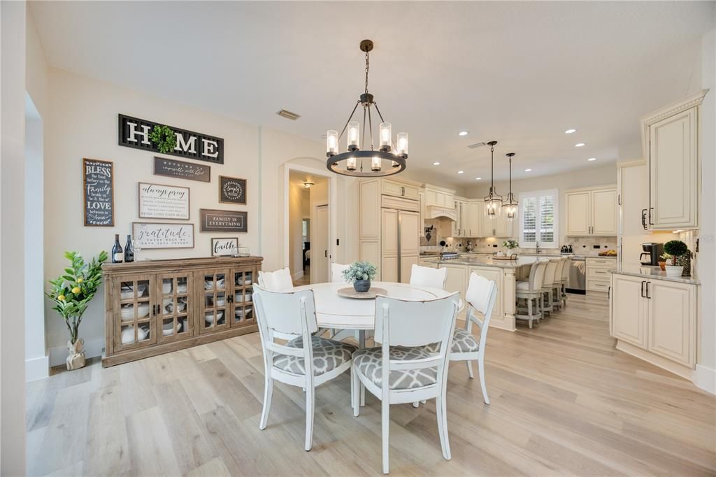 Casual dinette with updated light fixtures sits next to entrance to lanai