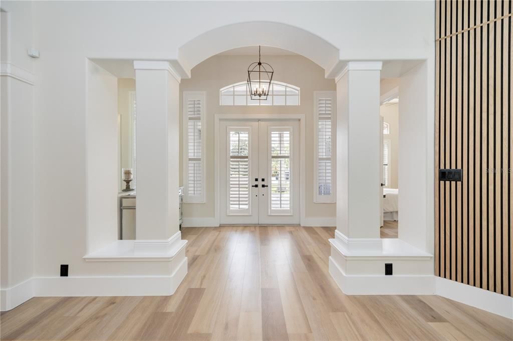 Majestic foyer with amazing architectural designs full of natural light flowing in from French Doors, sidelight and transom windows. Every little architectural detail down to the custom baseboards delivers exquisite luxury