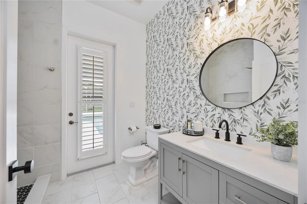 Third bathroom with access to Lanai. Beautiful newly installed wallpaper and adding glamour to this guest bathroom