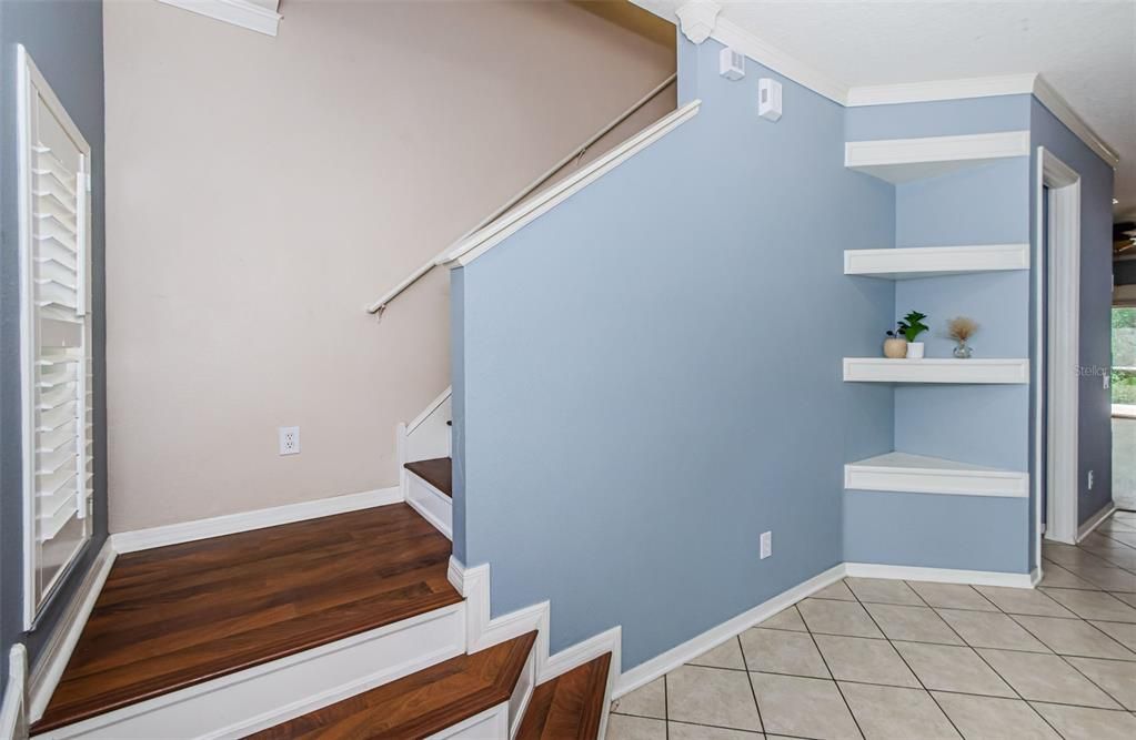 Entry way with architectural details including molding and wood staircase