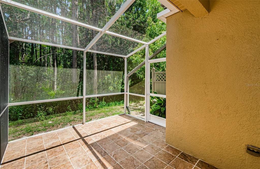 Screen enclosed back porch with privacy and preserve