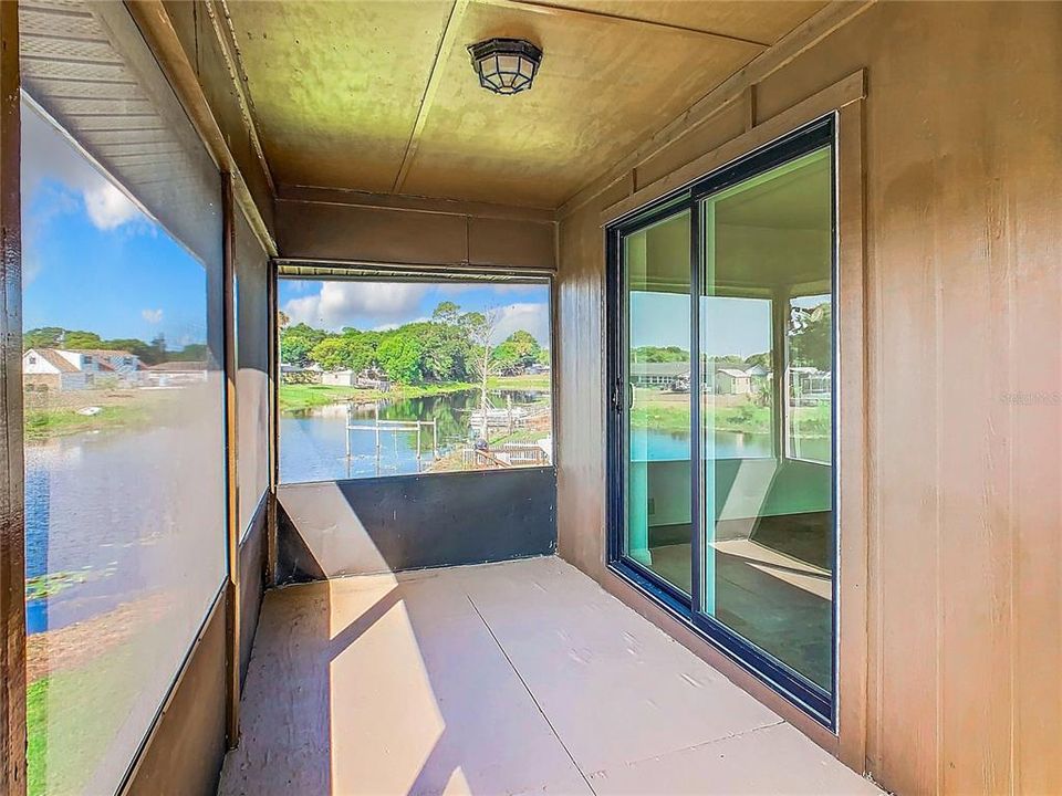 Screened porch with waterfront view.