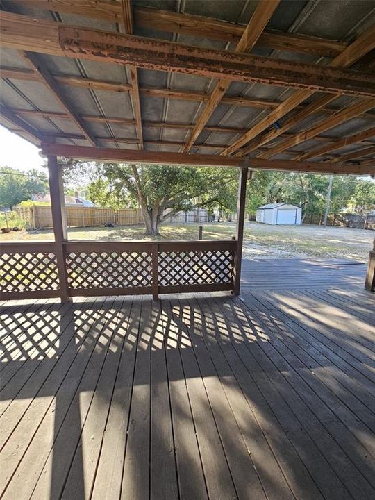 covered deck area from the back of the house with view of very large yard