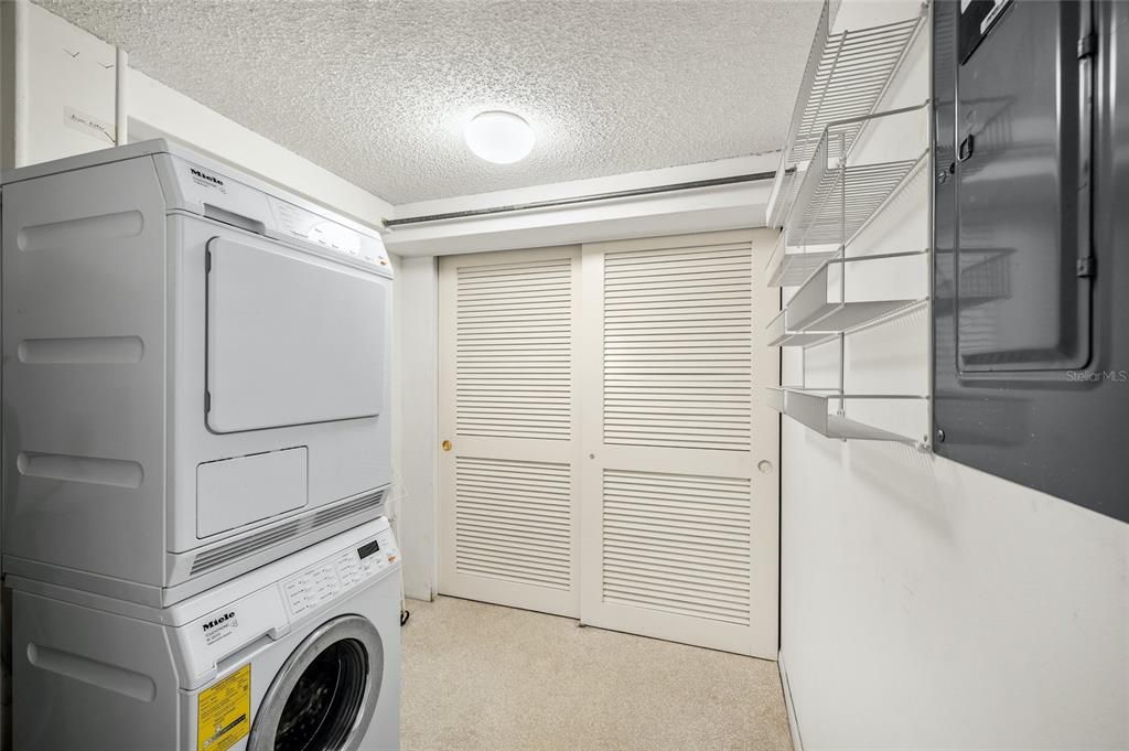 Large laundry room with storage is located down the hallway from the kitchen near the guest bathroom.