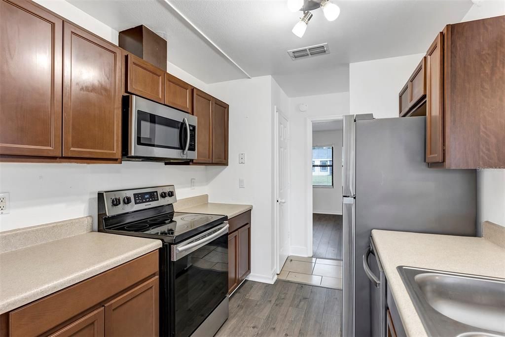 Kitchen with appliances, dual sink, ventilation, wooden cabinets and much much more.