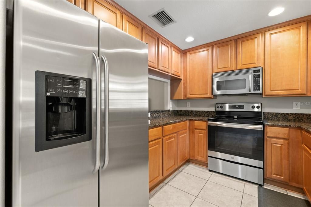 Granite counters, stainless steel appliances, wood cabinets with pull outs