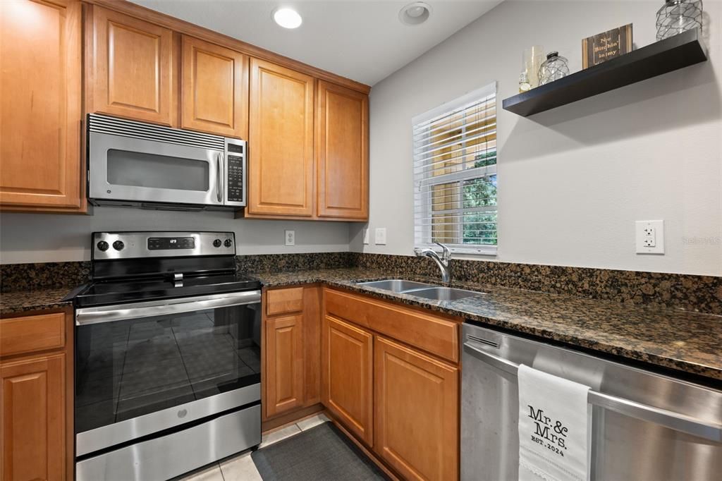 Granite counters, stainless steel appliances, wood cabinets with pull outs