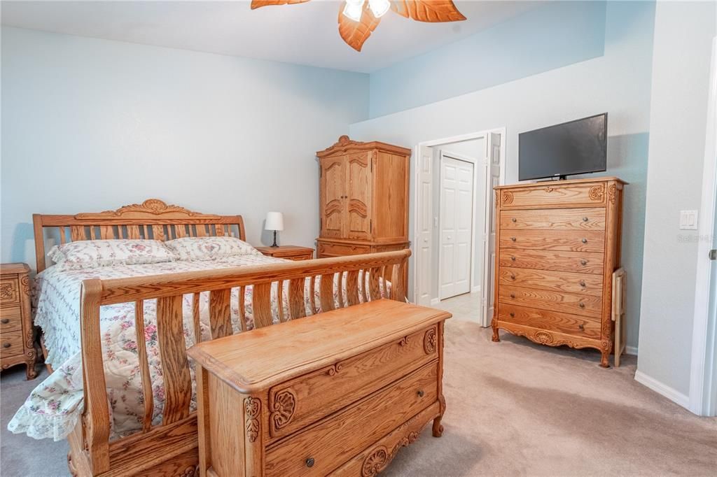 The primary bedroom features plush carpeting, a stylish ceiling fan and an ensuite bath.