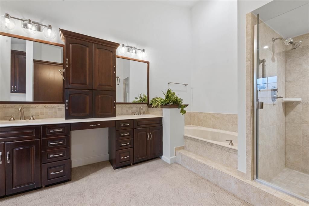 Primary Bathroom with dual vanities, tub, and separate shower stall