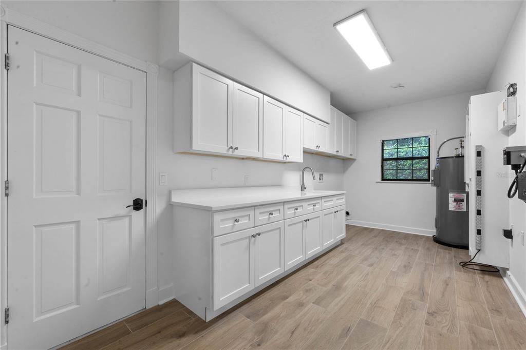 Laundry Room with sink.  All new cabinetry and quartz countertop.  This is off the kitchen and the door is to the garage.