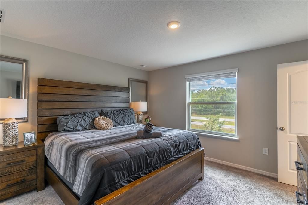 Primary bedroom with neutral carpeting and walk-in closet