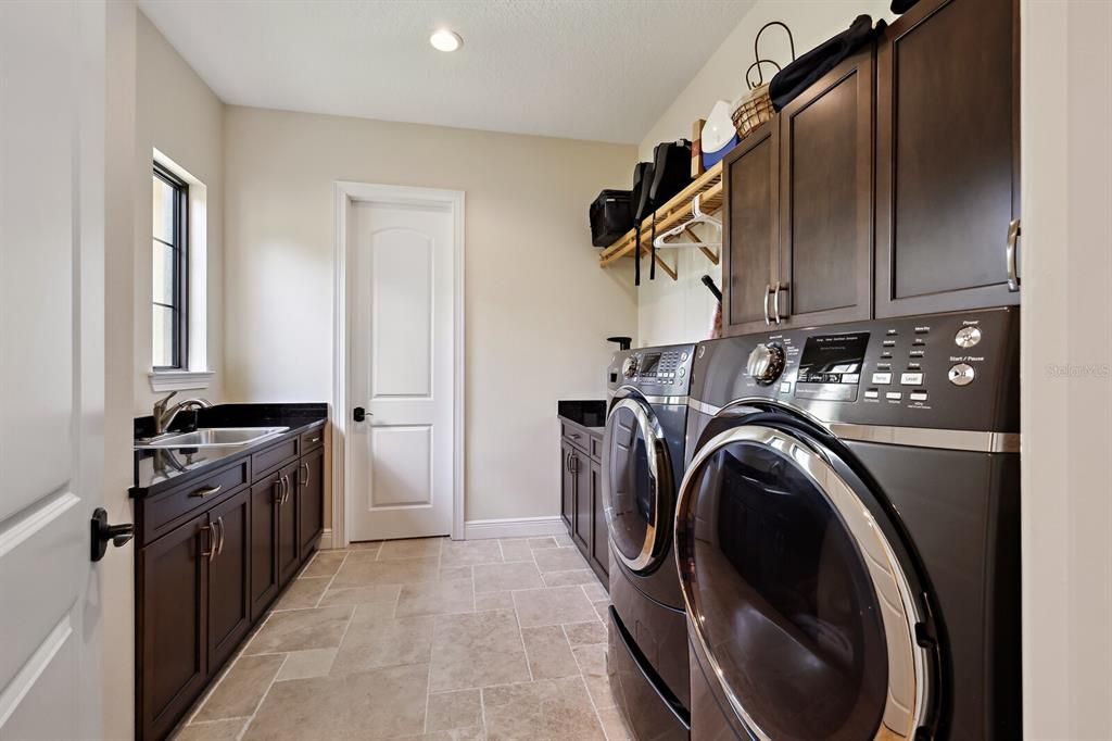 Large laundry room front load washer and dryer, sink and storage closet