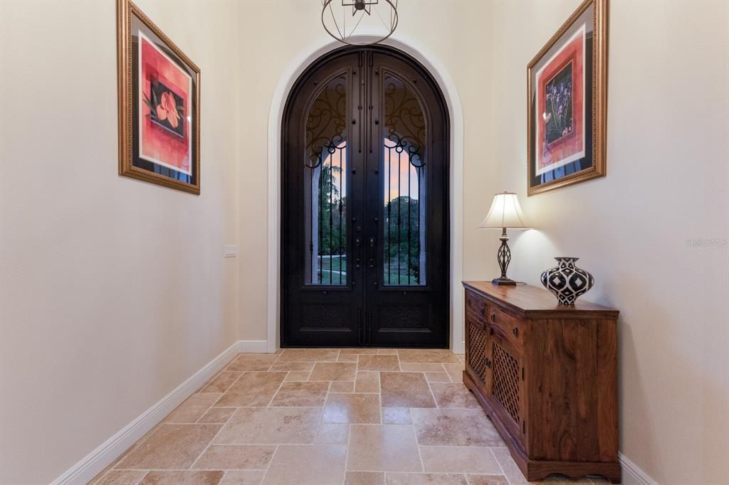 Stunning iron front entrance that opens into the 14' ceilings