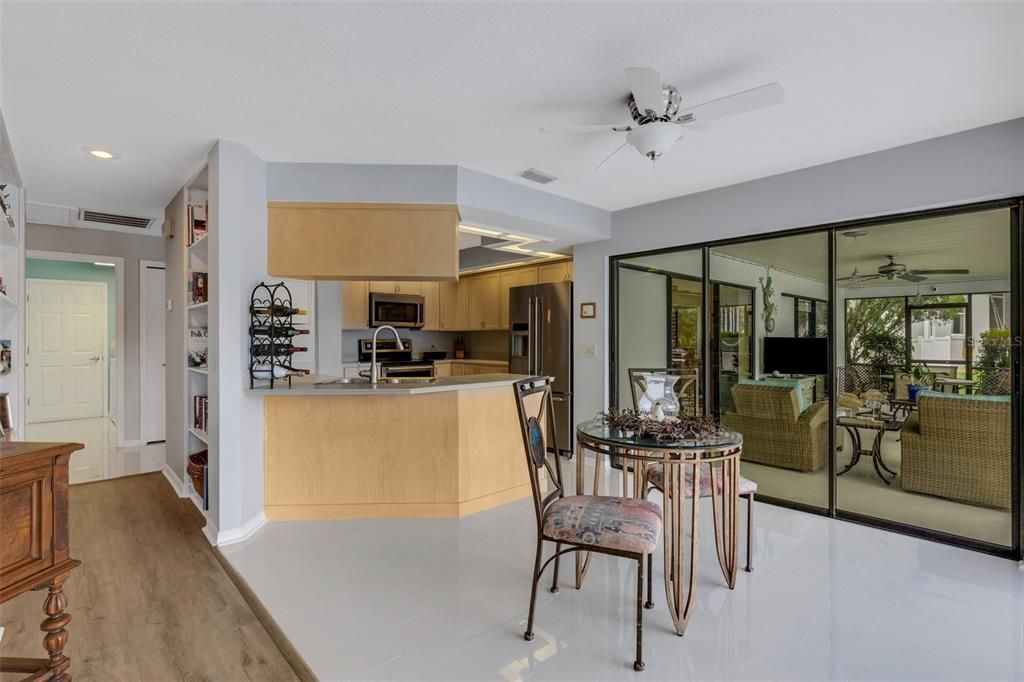 This view features the built-in book case/shelving that line the walls in the hall , into the indoor laundry just beyond.The Sliders in the kitchen are dual direction, meaning they will slider from the right or left.