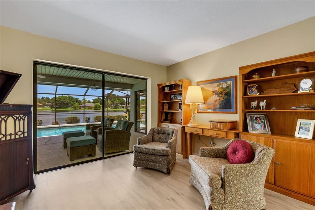 The living room features a great view of the lake along with pocketing sliders to the pool patio & lanai