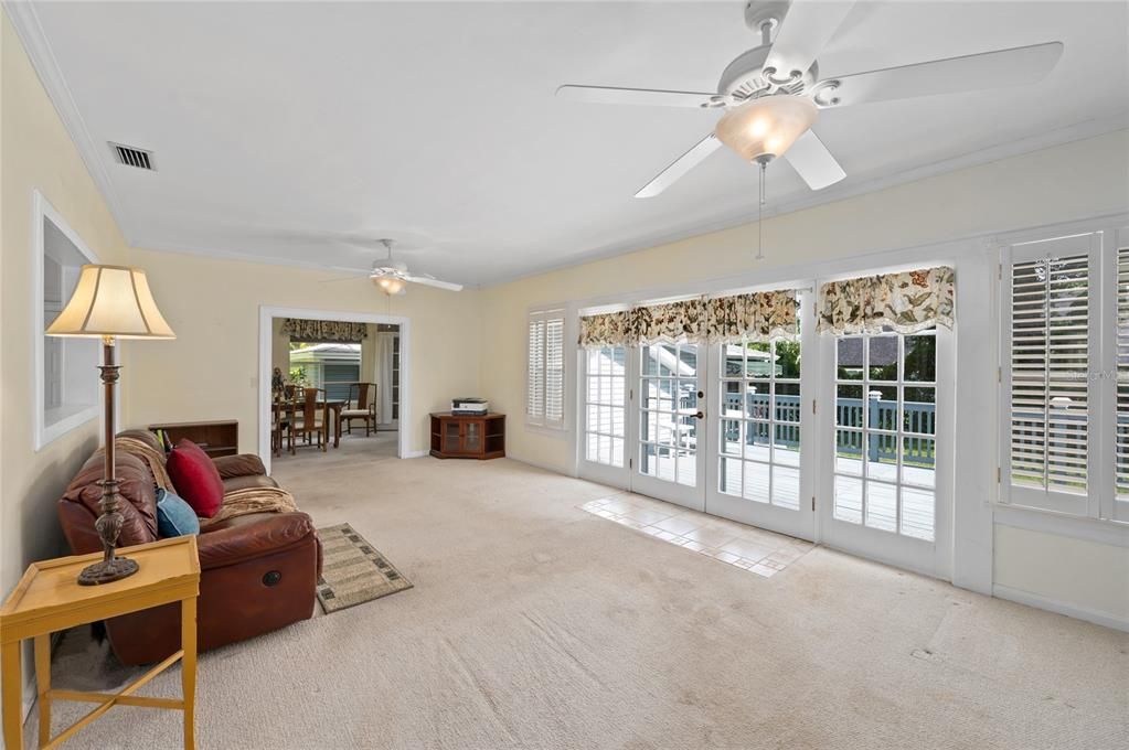 Living/Great Room with a full wall of french doors and windows overlooking the large outdoor patio space.