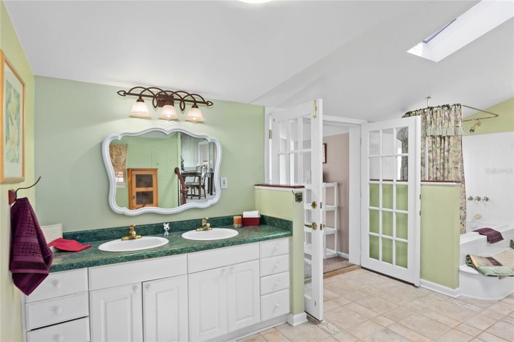 Primary bath has dual sinks, a tub with shower and a private water closet with linen space.