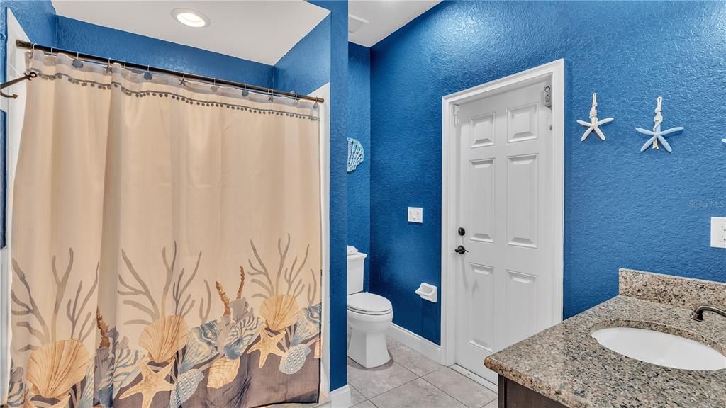 This full bathroom, has a shower and heads directly to the outside kitchen and pool area.