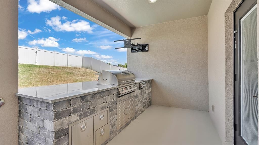 Outdoor Kitchen with a mounted BBQ and 2 gas burners.