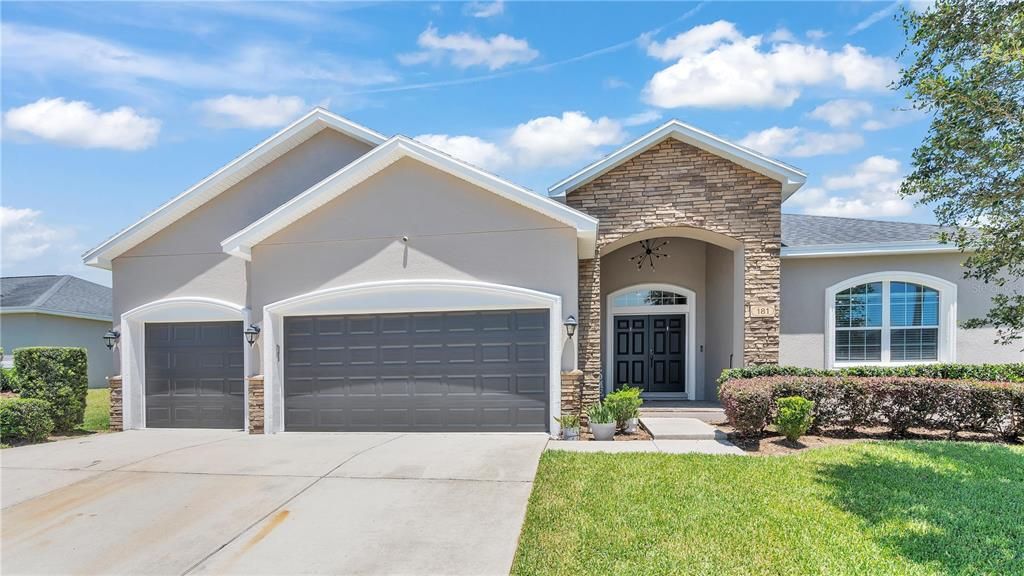 The front of the home features a wide driveway, with a 3 car garage.