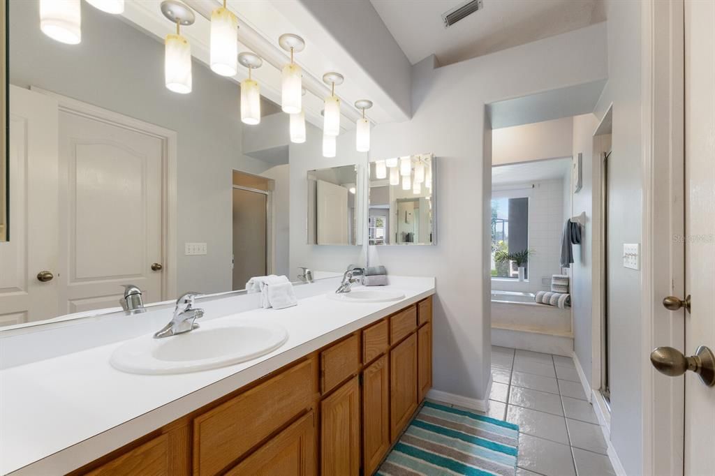 Primary Bath with 2 sinks and walk-in closet with custom shelving and drawers