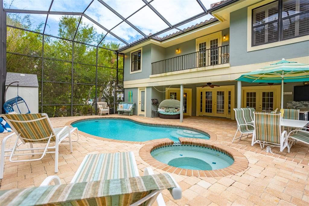 Pool with two story screen enclosure and waterfall hot tub