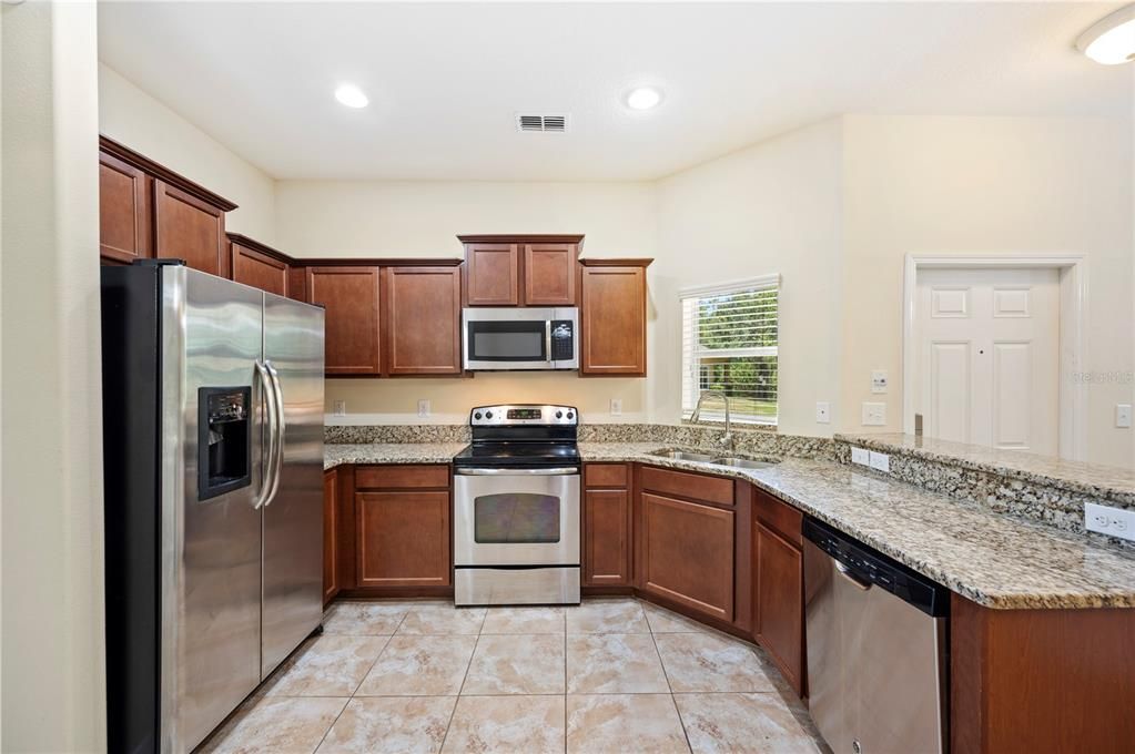 Kitchen with granite counters, stainless steel appliances and tile flooring for easy cleaning