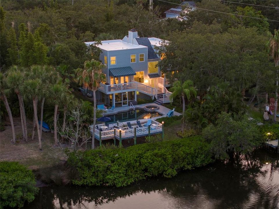 Welcome to 2385 Fiesta Drive, a serene and private oasis nestled on the peaceful boating waters of Phillippi Creek in Sarasota, FL. This exquisite property spans almost an acre, adorned with mature canopied Oak trees draped in Spanish moss, offering tranquility and natural beauty.