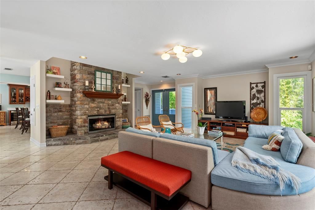 Enter through double glass front doors into the welcoming foyer and sunbathed living room which boasts a wood-burning stone fireplace with its chimney running up to the second story through the center of the home.